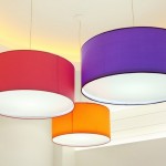 Purple, red and orange round stylish lampshades hang from ceiling